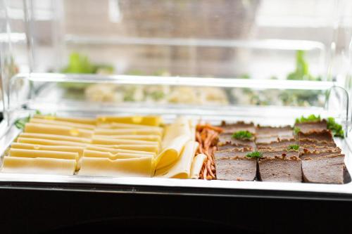 a tray of food with cheese and other foods at Willa Kłodzko-Zacisze - sauna, siłownia, komnata solna, parking in Kłodzko