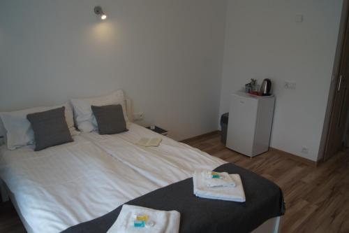 a bedroom with a white bed with two towels on it at Willa Wena in Ustka