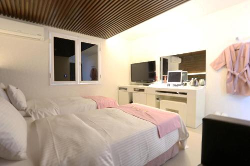 a bedroom with two beds and a desk with a sink at Q Hotel in Paju