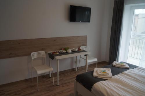 a room with a table and two chairs and a tv at Willa Wena in Ustka