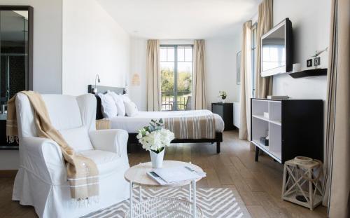 - un salon blanc avec un lit et un canapé dans l'établissement Castel Beau Site, à Perros-Guirec