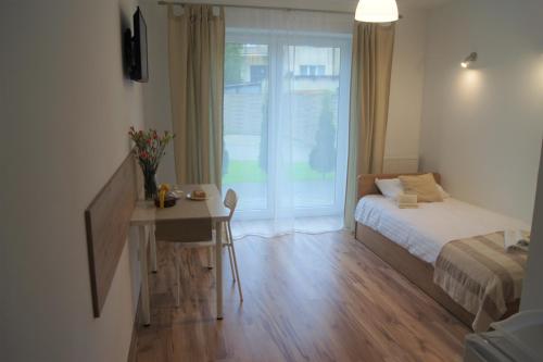 a bedroom with a bed and a desk and a window at Willa Wena in Ustka