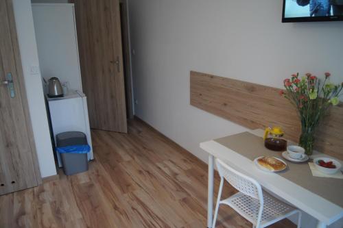 a small kitchen with a table and a small refrigerator at Willa Wena in Ustka