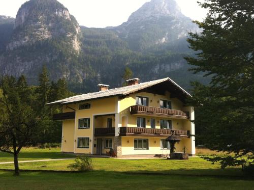 a house in the mountains with mountains in the background at Landhaus Lilly in Obertraun