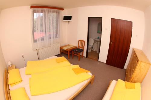 a bedroom with two beds and a table and chairs at Yacht club Barrandov in Kožlí u Orlíka