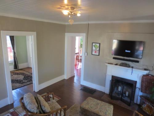 a living room with a fireplace and a flat screen tv at Historic Santa Rosa Cottage in Santa Rosa