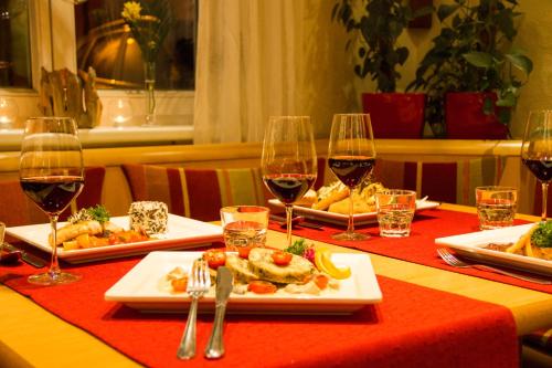 a table with three plates of food and glasses of wine at Hotel Drei König in Immenstadt im Allgäu