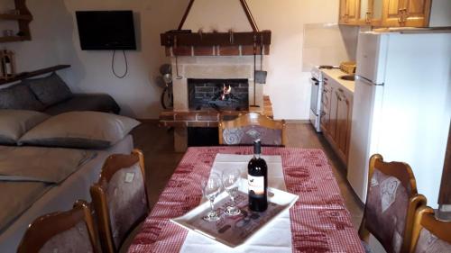 a living room with a table with a bottle of wine at Weekend House Petar in Lusnić