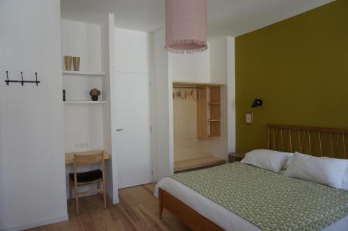 a bedroom with a bed and a green wall at midi03 in Carcassonne
