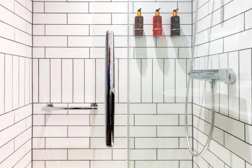 a shower with a black umbrella in a bathroom at The Hendrick Smithfield in Dublin