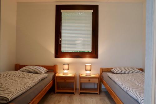 two twin beds in a room with a window at Holiday houses BARCA in Košice