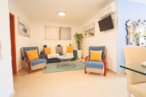 a living room with chairs and a couch and a table at Holidays Nazaré marginal in Nazaré