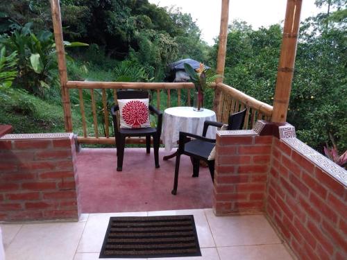 a patio with a table and chairs on a porch at Finca Colibrí Zafiro, Altos del Rosario in Cali