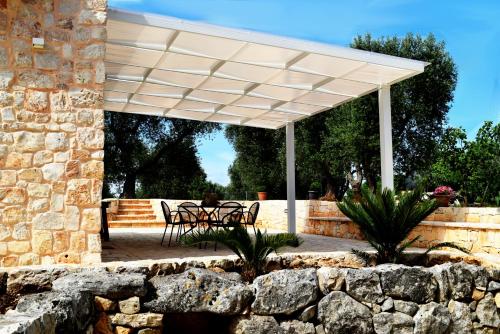 a white pergola over a patio with a table and chairs at Dimore Storiche - Ulivo di Aldo in Martina Franca