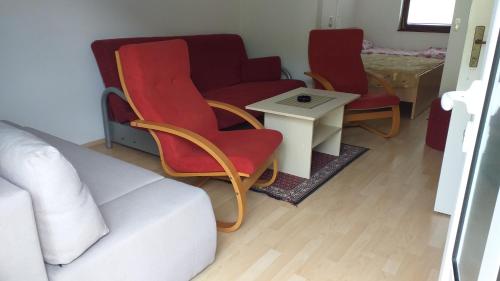 a living room with a couch and chairs and a table at TEA Apartmani in Bajina Bašta