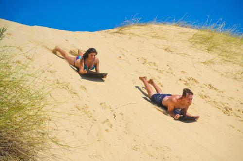 two people laying on surfboards on a beach at Adventure House - Colchester - 5km from Elephant Park in Colchester