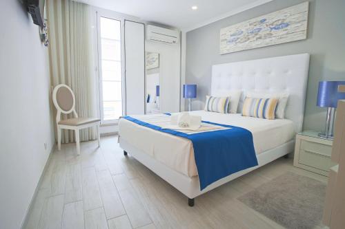Un dormitorio con una gran cama blanca y una ventana en Holidays Nazaré marginal, en Nazaré