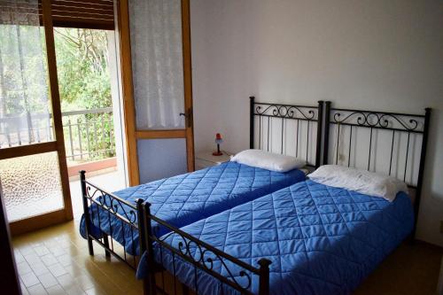 リド・ディ・イエゾロにあるVILLA CRISTINA N. 10のベッドルーム1室(青い掛け布団、窓付)