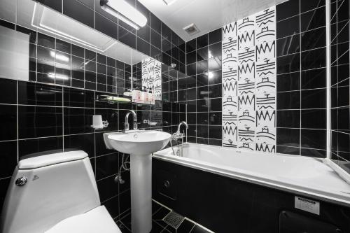a black and white bathroom with a toilet and a sink at Q Hotel in Paju