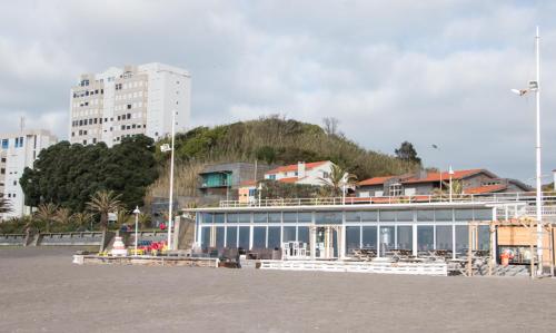 a large building with a mountain in the background at GuestReady - OceanView TopFloor w Terrace in Ponta Delgada