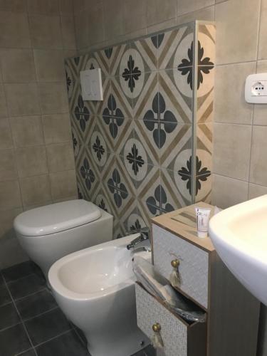 a bathroom with a toilet and a sink at Via Mazzini in Bazzano