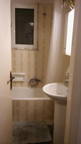 a bathroom with a tub and a sink and a window at CHRYSSA - ΧΡΥΣΑ in Patra