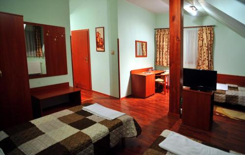 a hotel room with two beds and a desk at Hotel Złote Dęby in Warsaw