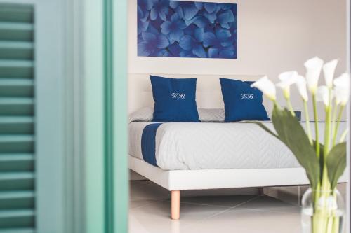 a bedroom with a bed with blue and white pillows at Villa Bellatrix in Massa Lubrense