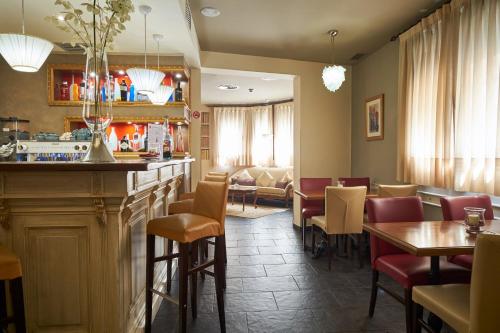 a restaurant with a bar and tables and chairs at Casona De Torres in Mondéjar