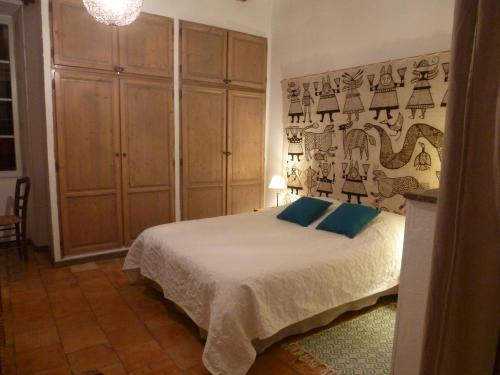 um quarto com uma cama com almofadas azuis em le rocher de Sampzon em Sampzon