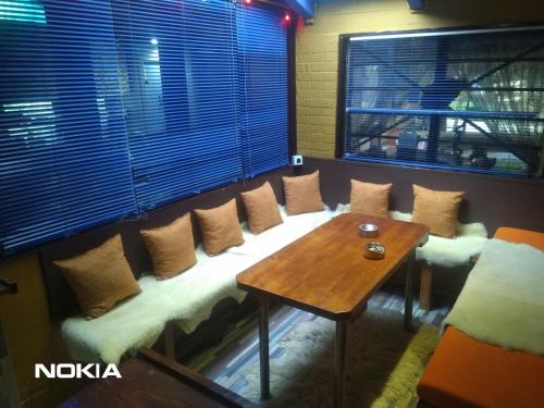 a room with a bench with pillows and a table at Holiday Home Nature Neno in Visoko