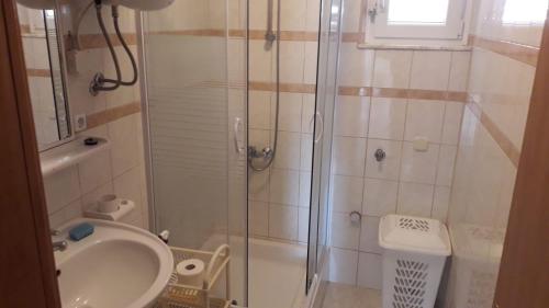 La salle de bains est pourvue d'une douche, d'un lavabo et de toilettes. dans l'établissement Apartment Hrgić Vir, à Vir