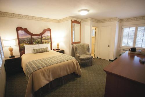 Habitación de hotel con cama y silla en El Bonita Motel en St. Helena