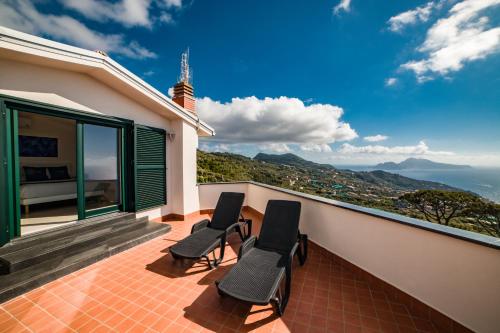 a balcony with two chairs and a view of the ocean at Villa Bellatrix in Massa Lubrense