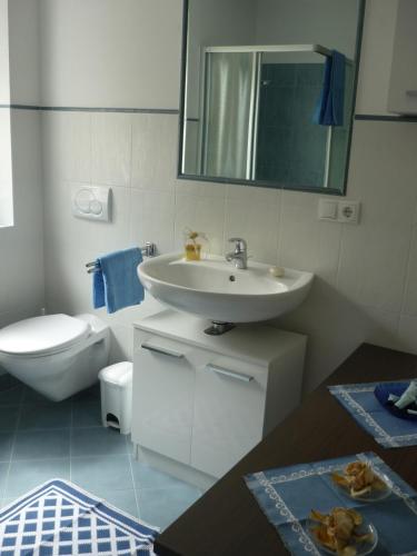 a white bathroom with a sink and a toilet at Appartements Schusterbauer in Natz-Schabs