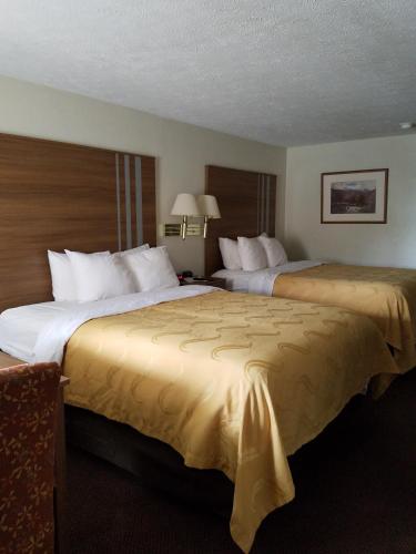 two beds in a hotel room with two at Quality Inn New River Gorge in Fayetteville