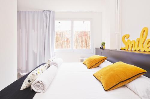 a bedroom with a large white bed with yellow pillows at Free Hostels Barcelona in Barcelona