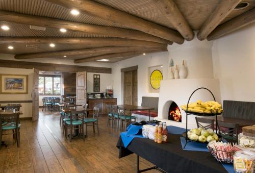 Habitación con chimenea, mesas y sillas en The Sage Hotel en Santa Fe