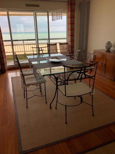 une salle à manger avec une table et des chaises avec vue sur l'océan dans l'établissement Royal Seavieuw, à Calais