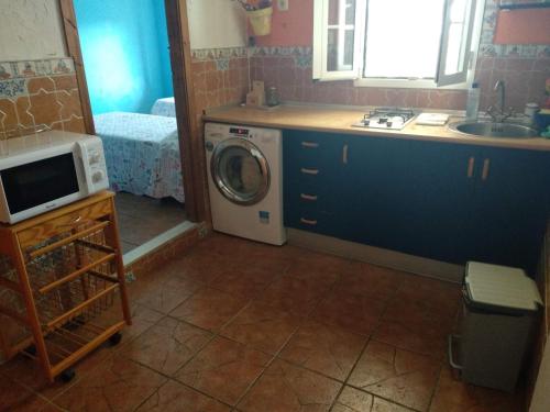 a kitchen with a washing machine and a sink at Villa La Canarita in Cala del Moral