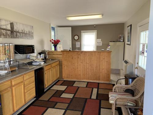 a kitchen with wooden cabinets and a counter top at Americas Best Value Inn Scarborough Portland in Scarborough
