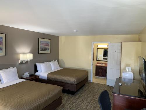 a hotel room with two beds and a television at Americas Best Value Inn Scarborough Portland in Scarborough