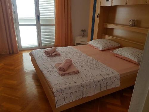 a bedroom with a bed with two towels on it at Apartments Ruzica in Makarska