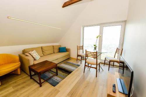 a living room with a couch and a table at Vivaldi Lake House in Meteliai