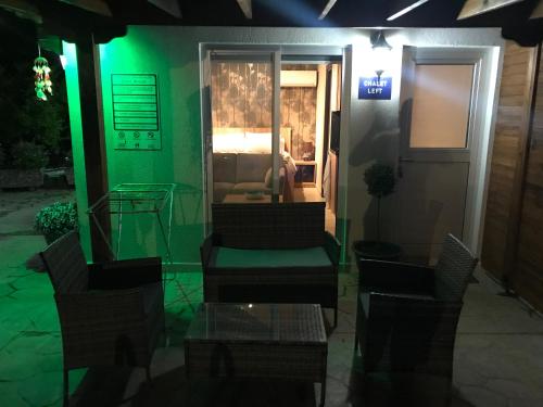 a room with green lighting and chairs and a bed at SOFROS VALLEY HILLS CHALET in Ayios Mamas