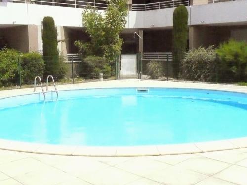une grande piscine bleue devant un immeuble dans l'établissement Tout confort ! Climatisation, Calme, Piscine, Parking Gratuit, Terrasse, Wifi, à Carcassonne