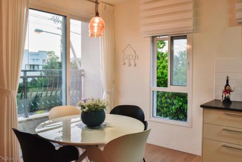 comedor con mesa, sillas y ventana en SOKOLOV Vacation Boutique Apartments by the sea in nahariya, en Nahariyya