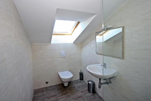 a bathroom with a sink and a toilet and a skylight at VILLA V&D in Milna