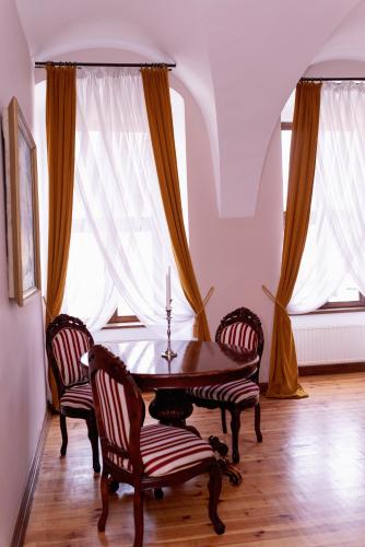 a dining room with a table and two chairs at Pałac Brody in Brody