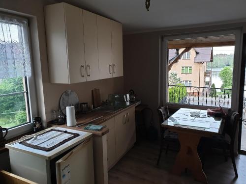 a kitchen with white cabinets and a table and a window at U Władzia in Gowidlino